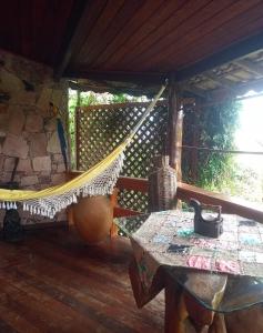 a hammock on the porch of a cabin at Jardim das orquídeas in Mucugê