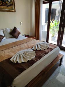 a bedroom with two beds and a large window at BBS Homestay in Nusa Lembongan