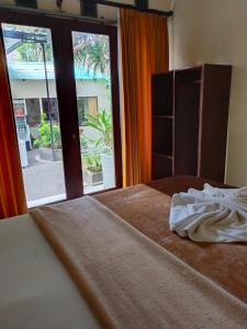 1 dormitorio con 1 cama y puerta abierta en BBS Homestay, en Nusa Lembongan