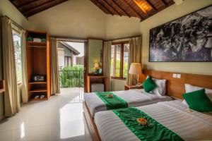 Postel nebo postele na pokoji v ubytování Bakung Ubud Resort and Villa