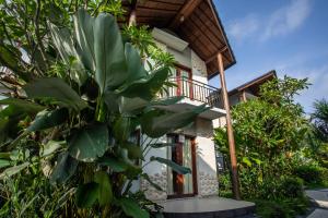 a house with a balcony and a bunch of plants at Bakung Ubud Resort and Villa in Ubud