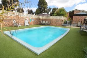 a large swimming pool in a yard with grass at Sandhurst Motor Inn Bendigo in Bendigo