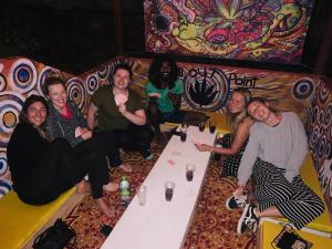 een groep mensen die rond een tafel zitten bij Ella City Reach Hostel in Ella