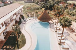 einen Luftblick auf einen Pool mit Palmen des Resorts in der Unterkunft Kos One Hostel in Canggu