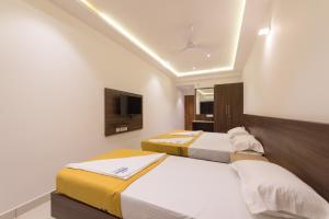 A bed or beds in a room at Hotel Karuna Residency