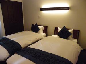dwa łóżka siedzące obok siebie w pokoju w obiekcie Chalet Fuyuri w mieście Furano