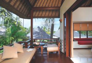 a balcony of a house with a table and chairs at Qunci Villas Resort in Senggigi +37 photos
