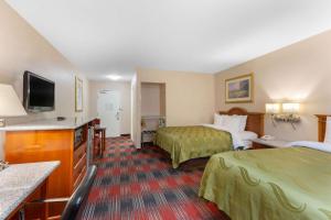 a hotel room with two beds and a flat screen tv at Quality Inn & Suites Oceanside Near Camp Pendleton in Oceanside