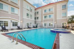 una piscina in un hotel con sedie e tavoli di Comfort Inn & Suites Cedar Hill Duncanville a Cedar Hill