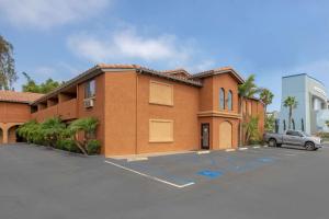 a building with a car parked in a parking lot at Quality Inn & Suites Oceanside Near Camp Pendleton in Oceanside