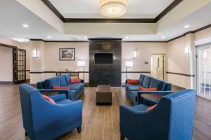 a lobby with blue couches and a fireplace at Comfort Inn & Suites Cedar Hill Duncanville in Cedar Hill