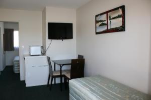 a hotel room with a bed and a table and a television at 88 Wallace Court Motel in Wellington