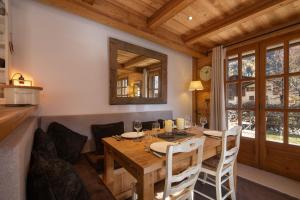 a dining room with a wooden table and a mirror at Chalets d'Henri 63 - Happy Rentals in Chamonix