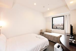 Postel nebo postele na pokoji v ubytování Sotetsu Fresa Inn Yokohama Sakuragi-cho