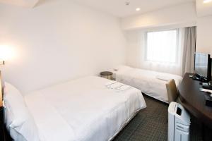 Postel nebo postele na pokoji v ubytování Sotetsu Fresa Inn Yokohama Sakuragi-cho