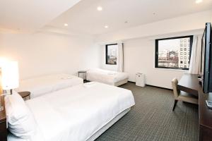 Postel nebo postele na pokoji v ubytování Sotetsu Fresa Inn Yokohama Sakuragi-cho