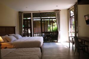 a bedroom with two beds and a table and chairs at Mountain View GuesthouseChiangmai in Chiang Mai