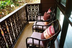 a row of chairs with pillows on a balcony at Mountain View GuesthouseChiangmai in Chiang Mai