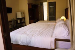 a bedroom with a large bed with white sheets at Mountain View GuesthouseChiangmai in Chiang Mai