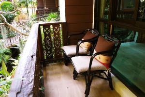 two chairs sitting on the porch of a house at Mountain View GuesthouseChiangmai in Chiang Mai
