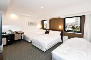 Postel nebo postele na pokoji v ubytování Sotetsu Fresa Inn Yokohama Sakuragi-cho
