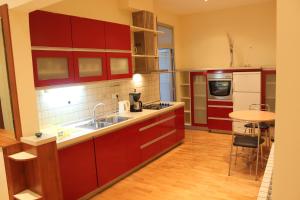 a kitchen with red cabinets and a table in it at Apartman Buna in Sarajevo