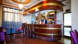 a bar in a restaurant with a man standing behind it at Hera Addis Hotel in Addis Ababa