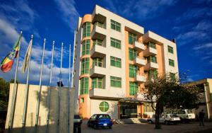 亚的斯亚贝巴Hera Addis Hotel的一座高楼，前面停着汽车