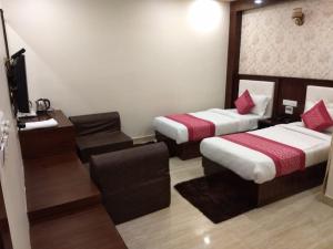 a hotel room with two beds and a television at Hotel Rahil Palace in Varanasi