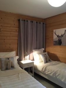 a bedroom with two beds and a table with a deer picture at Chalet Epinette Appt 204, classé 4 étoiles in Valloire