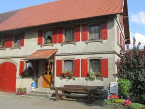 een huis met rode luiken en een bank ervoor bij Gasthaus zum Goldenen Roß in Creglingen