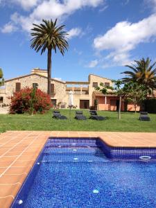 uma piscina em frente a uma casa com palmeiras em Can Mas em Sant Pere Pescador