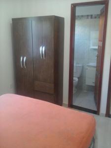 łazienka z drewnianą szafką i toaletą w obiekcie Costa Brasil w mieście Coroa Vermelha