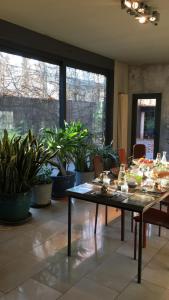 a dining room with a table and some plants at B&B Design in Bologna