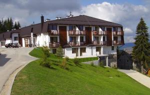 ein großes Haus auf einem Grashügel in der Unterkunft Eko-FIS Vlašić in Vlasic