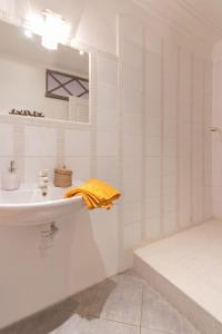 a white bathroom with a sink and a shower at Topaze in Monnières