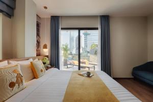 a bedroom with a large bed with a large window at Little Saigon Boutique Hotel in Ho Chi Minh City