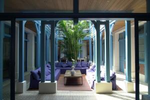 a living room with purple couches and a tree at Villa d'Eaux in Villers-sur-Mer