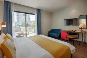 a hotel room with a large bed and a desk at Little Saigon Boutique Hotel in Ho Chi Minh City