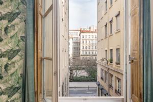 an open window with a view of a city at Honorê - Suites Amboise in Lyon