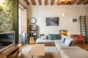 a living room with a couch and a tv at Honorê - Suites Amboise in Lyon