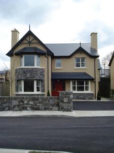 a large house with a stone wall in front of a street at Ardmullen in Kenmare