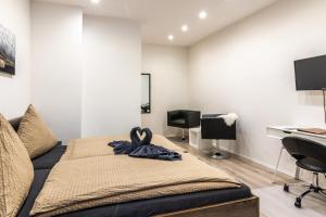 a bedroom with a bed and a desk and a computer at Hotel Martz in Pirmasens