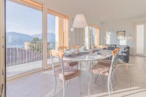 a dining room with a table and chairs and a balcony at Casa Tre Sole in Lierna