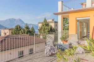 a balcony with chairs and a view of mountains at Casa Tre Sole in Lierna