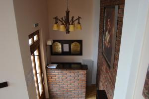 a hallway with a brick fireplace with a chandelier at Pensiunea Mason's in Râşnov