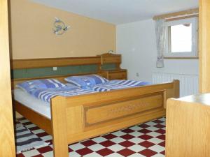 1 dormitorio con cama de madera y almohadas azules en Ferienwohnungen Waldblick en Waldmünchen