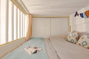 uma cama num pequeno quarto com uma janela em Chengdu Jinjiang·Taikoo Li· Locals Apartment 00177440 em Chengdu