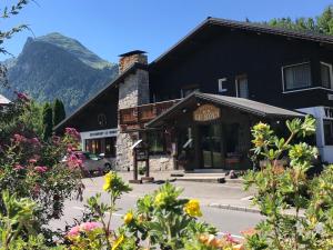 Czarny budynek z kwiatami przed nim w obiekcie Hotel Le Soly w mieście Morzine