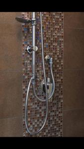 eine Dusche im Bad mit Mosaikfliesenwand in der Unterkunft civico118 short lets in Neapel